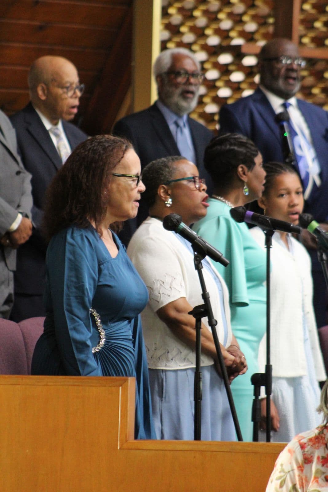 Members of the choir and the pulpit party standing together in worship