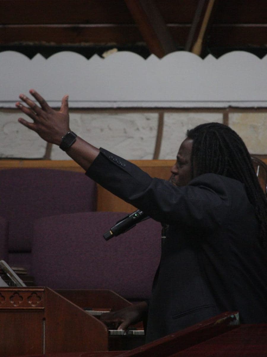 A member with an arm raised in praise during worship
