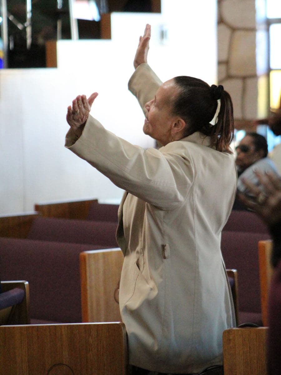 A member with a raised hand in worship